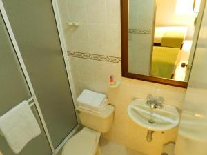 y baño con aseo, lavabo y ducha. en Hotel Palma 70, en Medellín