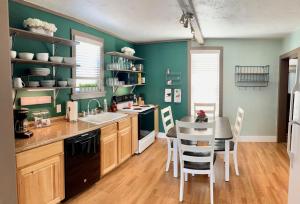 una cucina con pareti verdi e tavolo e sedie di Walker's Place a Outback Mobile Home Settlement Altre 21 foto