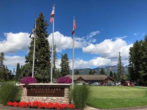 un cartello per un golf club con due bandiere di Walker's Place a Outback Mobile Home Settlement