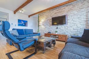 a living room with blue furniture and a brick wall at Apartment Zagreb Deluxe in Zagreb