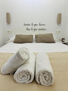 uma cama com toalhas e uma citação na parede em LA TERRAZA DE LAUREL Aire acondicionado Insonorizado em Logroño