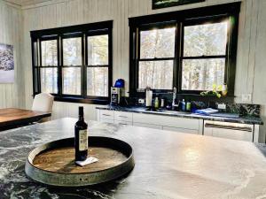 a bottle of wine sitting on a table in a kitchen at Whispering Pines Chalet in Vista +44 photos