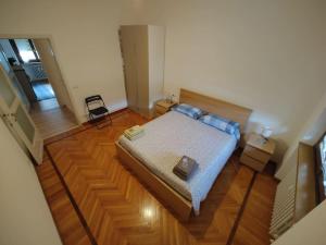 una piccola camera con letto e pavimento in legno di Casa Battisti a Sondrio