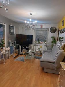 a living room with a couch and a flat screen tv at Queen house apartman in Zagreb