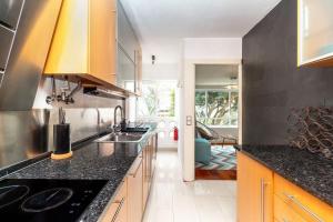 uma cozinha com bancadas pretas e um lavatório em Ola Lisbon - Olaias em Lisboa