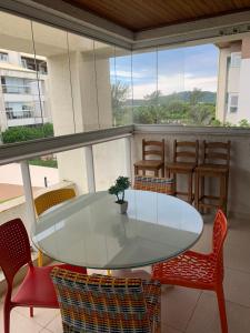 een witte tafel en stoelen op een balkon bij Apartamento pé na areia em frente a Ilha do Campeche in Florianópolis