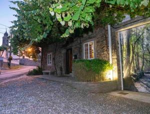 a small brick house on the side of a street at Santaia en Casal de Calma in O Pedrouzo