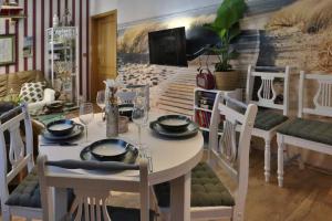 une salle à manger avec une table et des chaises blanches dans l'établissement Charmante Wohnung am Schönberg, à Sonneberg