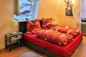a bedroom with a bed with orange comforters and a window at Charmante Wohnung am Schönberg in Sonneberg