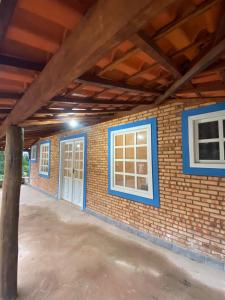 a garage with two windows and a brick wall at Ibitisuítes chalé in Lima Duarte