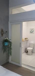 een badkamer met een toilet en een schuifdeur bij San Antonio in Medellín