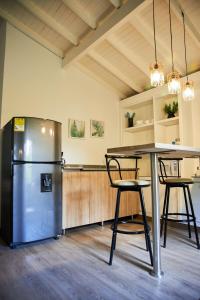 een keuken met een koelkast en een tafel met stoelen bij San Antonio in Medellín
