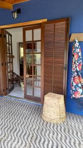 una habitación con puerta y taburete de paja frente a una casa en Aconchego da Roça, en Gonçalves