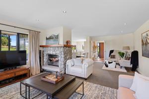 a living room with a fireplace and a tv at Yuki's Chalet - Terrace Downs in Windwhistle