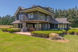 a large house with a porch on a lawn at Yuki's Chalet - Terrace Downs in Windwhistle