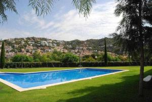 ein Schwimmbad in einem Hof mit einer Stadt im Hintergrund in der Unterkunft Sitges PORT Con piscina a 5 minutos de la playa in Barcelona