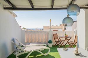 a small balcony with a table and chairs at Sunny Studio Nerja in Nerja