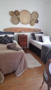 a bedroom with two beds and a table on the wall at Aconchego da Roça in Gonçalves