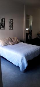1 dormitorio con 1 cama grande con sábanas blancas en Moderno departamento con balcón en Recoleta en Buenos Aires