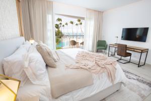 蓬塔卡納的住宿－Destination Jelly / Playa Coral Condo，卧室配有一张白色大床和一张书桌