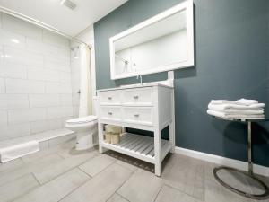 La salle de bains est pourvue d'un lavabo blanc et de toilettes. dans l'établissement Courtesy Inn & Suites, à Rosemead