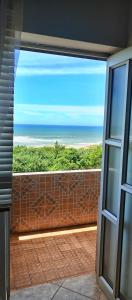 a view of the ocean from an open window at Breezy Seaview-On the Beach- Open balcony in Amanzimtoti