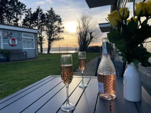 zwei Weingläser und eine Flasche auf dem Tisch in der Unterkunft Wight Waves Holidays in Sandown