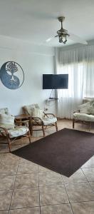 a living room with chairs and a rug on the floor at Breezy Seaview-On the Beach- Open balcony in Amanzimtoti