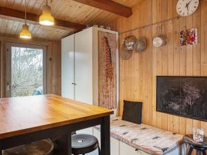 a kitchen with a table and a clock on the wall at 8 person holiday home in Holb k in Holbæk