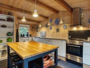 a kitchen with wooden walls and a wooden table at 8 person holiday home in Holb k in Holbæk