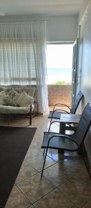 a living room with two chairs and a couch at Breezy Seaview-On the Beach- Open balcony in Amanzimtoti