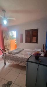 a bedroom with a bed and a table and a chair at Suites Solar dos Arcanjos Guaramiranga in Guaramiranga