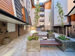 un patio de un edificio con un banco y plantas en Apartamento Villaggio Del Veneto 1 dorm by Achei, en Canela