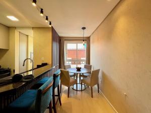 a kitchen and dining room with a table and chairs at Apartamento Villaggio Del Veneto 1 dorm by Achei in Canela