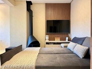 a bedroom with a bed with a fireplace and a tv at Apartamento Villaggio Del Veneto 1 dorm by Achei in Canela
