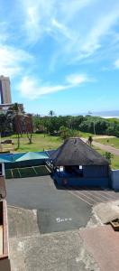 a building with a black roof in a parking lot at Breezy Seaview-On the Beach- Open balcony in Amanzimtoti