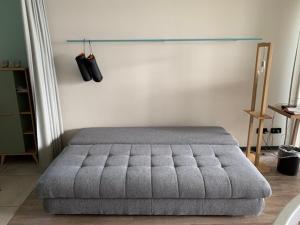 a bedroom with a gray tufted bed in a room at Ferienwohnung am See mit Terrasse in Ascheberg