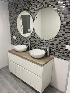 een badkamer met twee wastafels en twee spiegels bij Estadio playa in Almería +17 foto's