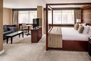 a hotel room with a bed and a living room at Mercure Glasgow City Hotel in Glasgow +33 photos