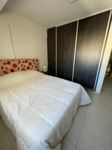 1 dormitorio con cama blanca y armario de madera en Federal 498 en La Rioja