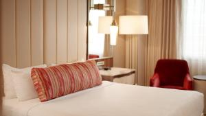 a hotel room with a bed and a red chair at Grand Sierra Resort and Casino in Reno