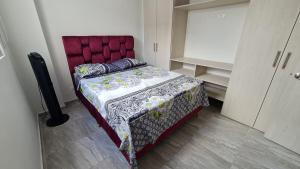 1 cama con cabecero rojo en una habitación en Apartamento Entero Ibague - Parqueadero - Nogal, en Ibagué
