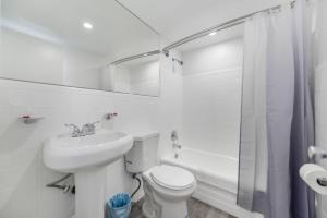 a white bathroom with a toilet and a sink at Beachfront Getaway Studio with Parking - M21 in Hollywood +10 photos
