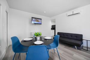 a dining room with a black table and blue chairs at Beachfront Getaway Studio with Parking - M21 in Hollywood