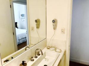 a bathroom with a sink and a mirror at Top Apart Leblon - com piscina na cobertura, sala de ginastica e garagem in Rio de Janeiro