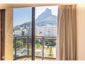 a window with a view of a mountain at Top Apart Leblon - com piscina na cobertura, sala de ginastica e garagem in Rio de Janeiro