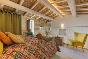 ein Schlafzimmer mit einem großen Bett und einem gelben Stuhl in der Unterkunft Corte del Parco in Muro Leccese
