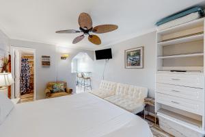 Schlafzimmer mit einem weißen Bett und einem Deckenventilator in der Unterkunft Beachview 208 in Gulf Shores