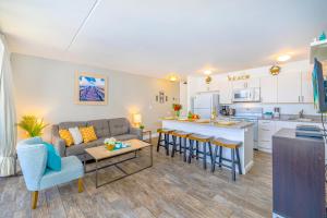 a living room and kitchen with a couch and a table at Aloha Vibes, Ocean & City Views with Free Parking! in Honolulu