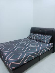 a bed with a black bed frame and two pillows at Homestay baitijannati in Pasir Mas
